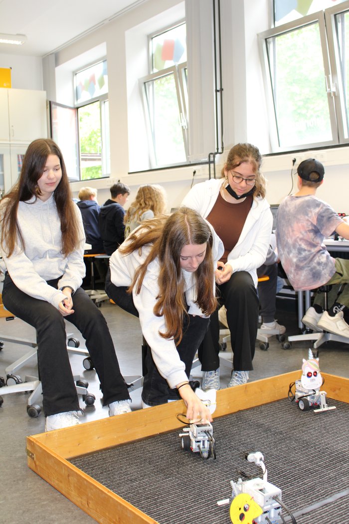 Schülerinnen starten ihr Programm auf dem Roboter