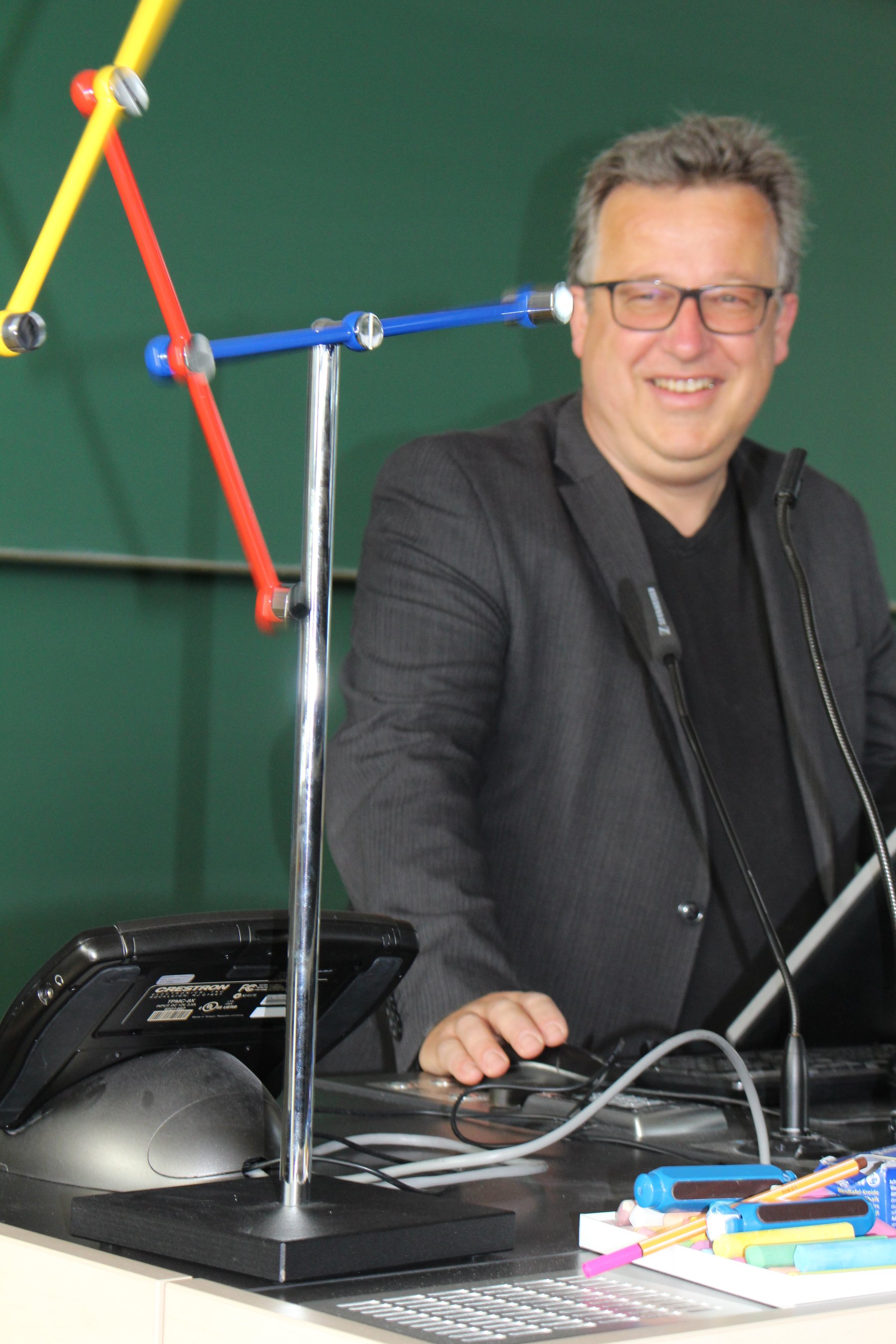 Mann lächelt Physikexperiment mit dreifarbigen wirbelnden Stangen an