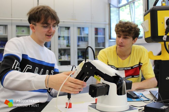 Zwei Schüler mit einem Roboterarm