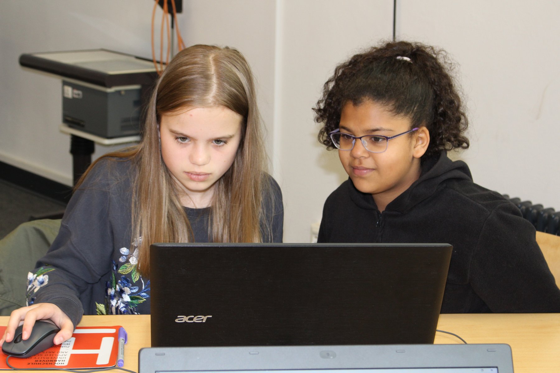 Zwei Mädchen blicken gespannt auf Ihren Laptop
